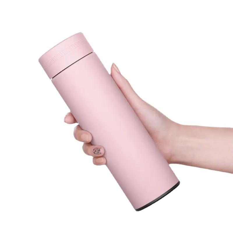 Smart water bottle in pink held in hand, stainless steel design for hydration tracking.