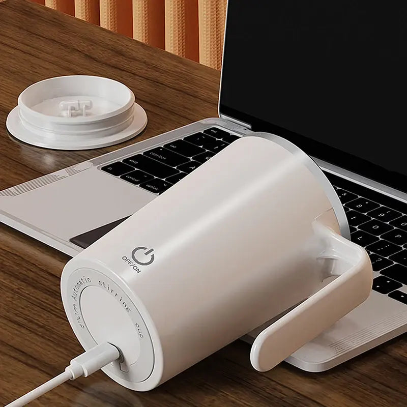 Automatic Self-Stirring Magnetic Mug on a desk near a laptop, showcasing its effortless stirring feature for perfectly mixed drinks.