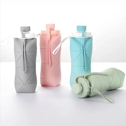 Compact folding water cups in gray, pink, blue, and green for outdoor adventures.