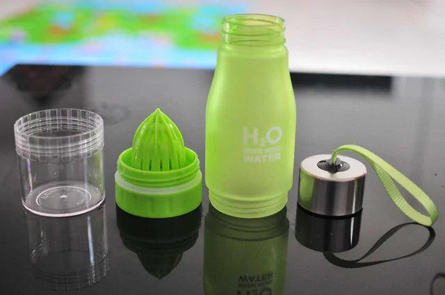 Fruit Infusion Water Bottle with green infuser and leak-proof cap on a table.